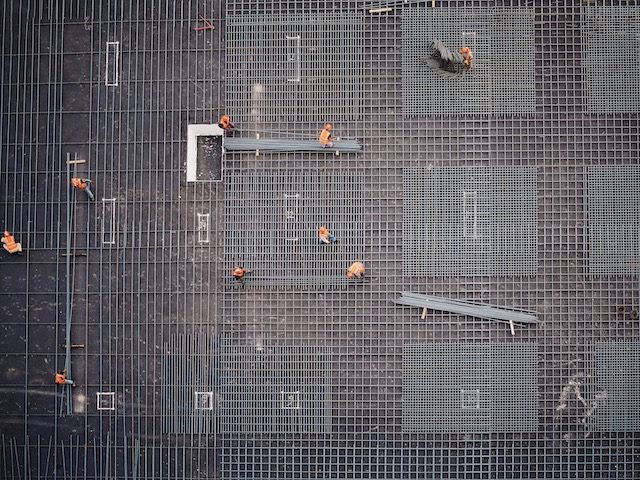 construction site, construction workers from above working in a grid pattern