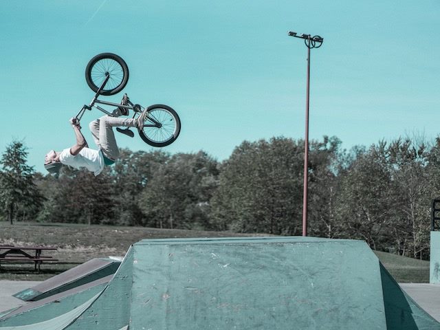 guy  on a bike doing a flip off  a  ramp