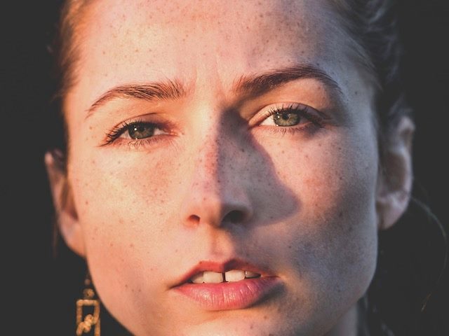 close up of young woman, looking skeptical