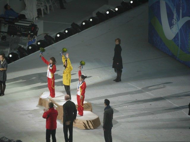 women on a podium celebrating a competition.