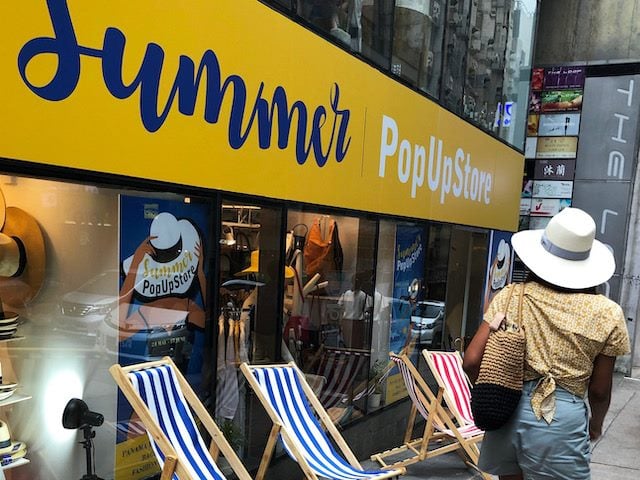 woman walking past a summer pop up shop