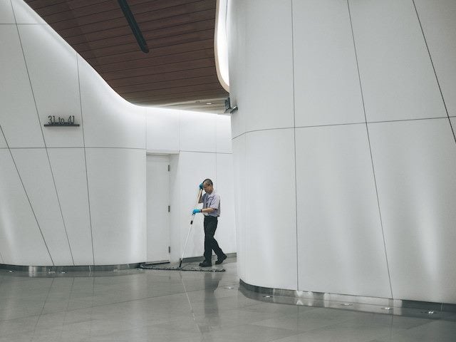 man sweeping the floor in an office building