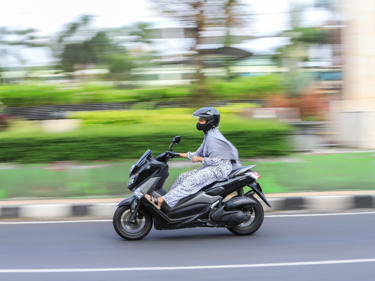Motorcyclist speeding ahead with blurred background to capture the acceleration.