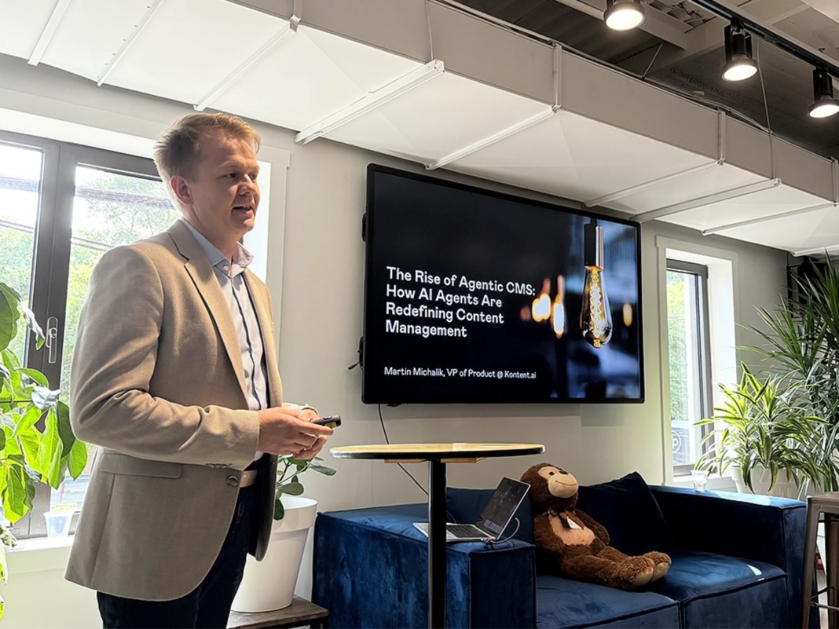 Martin Michalik, VP of product at Kontent.ai, giving a presentation on the new Agentic CMS product with a slide deck on a TV screen.
