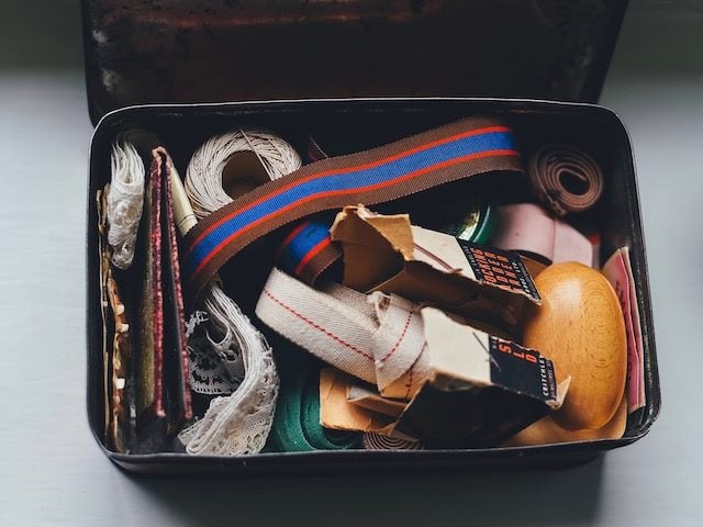 vintage tin holding sewing supplies