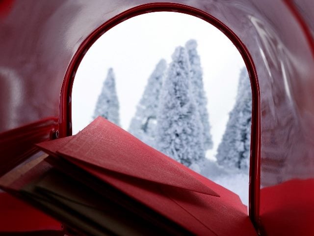 Shot from inside a red mail box filled with red letters. 