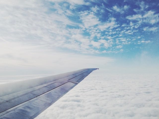 view from inside a plane of the wing and clouds