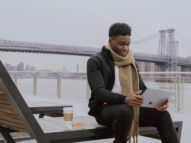 man working outside in the cold on a tablet