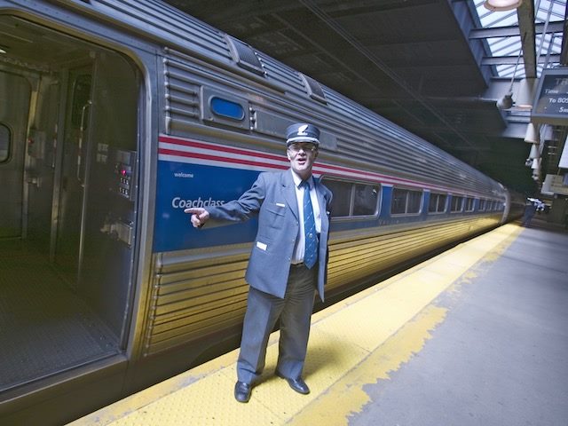 train conductor saying all aboard next to an open train door