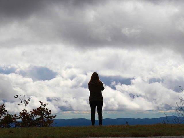 woman standing in the clouds