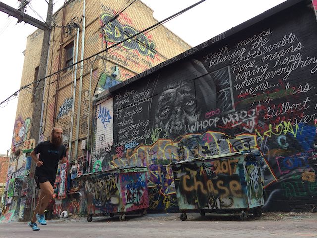 runner in front of a graffiti-covered wall