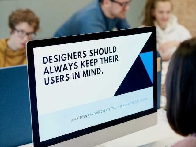 someone working on a screen which says "designers should always keep their users in mind"