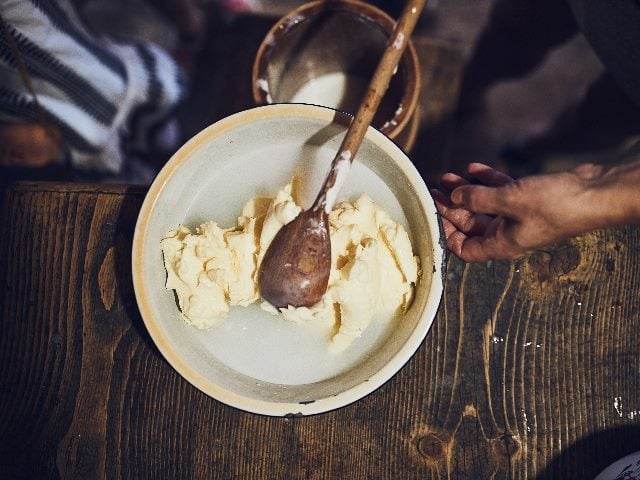 Making butter with butter churn, from the top-level view showing just a human hand doing the churning.