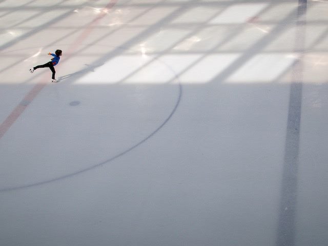 ice skater alone on ice, practicing figure 8