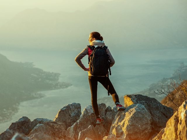 Female photographer on the top of mountain.