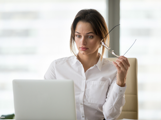 Surprised businesswoman reading through new privacy and copyright regulations that will impact her online community and user generated content strategy