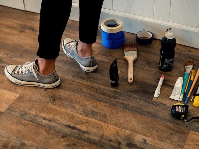 view of a person standing with a number of home improvement tools around their feet 