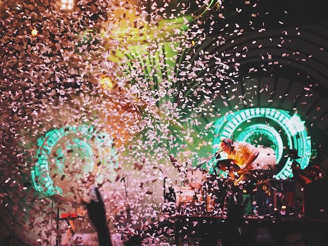 concert scene with neon lights, confetti, crowd and music
