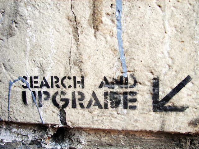 graffiti on wall saying "search and upgrade"