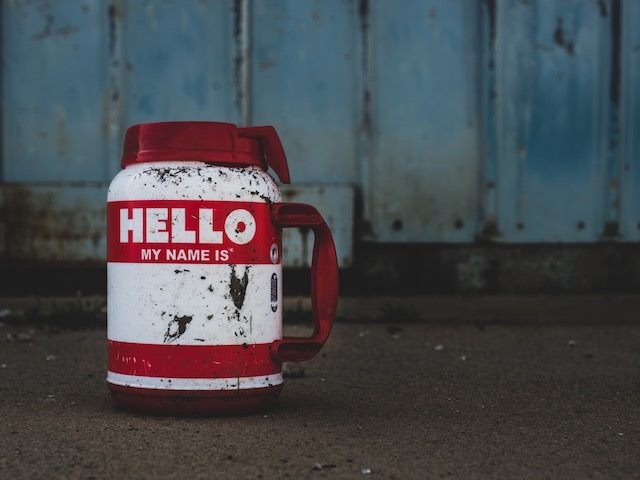 "hello my name is" written on a mug covered in mud