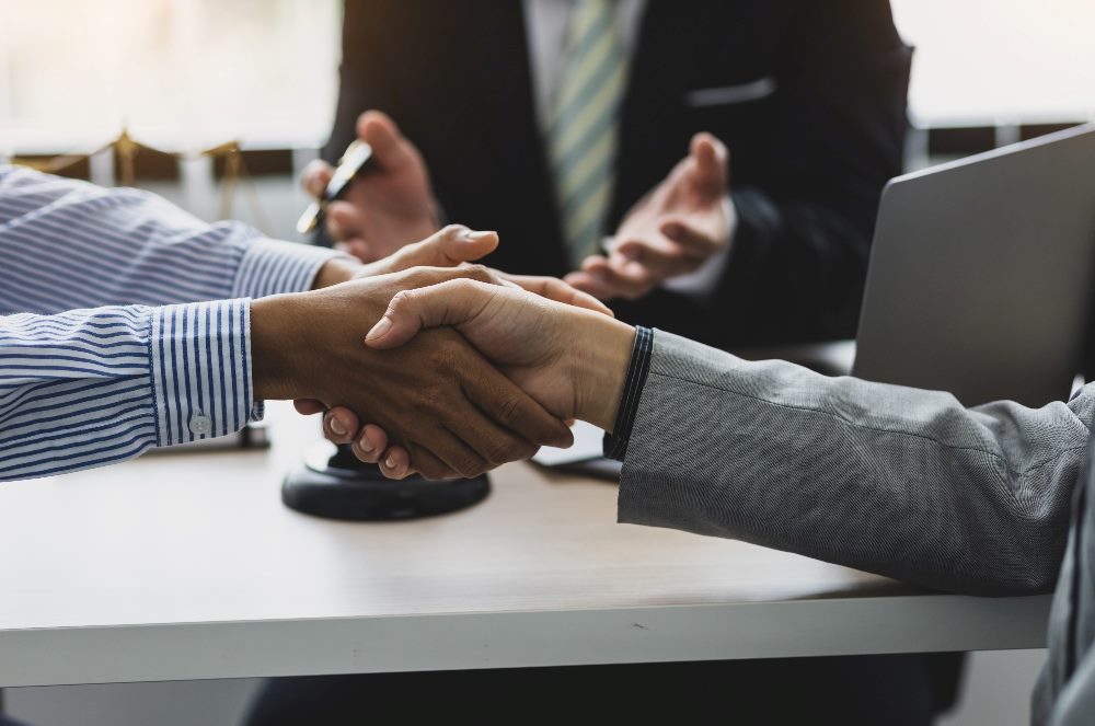 Business associates compromise and shake hands in piece about using a customer-centric approach.