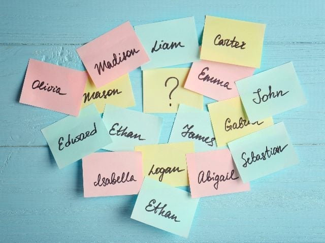  Paper stickers with different names on color wooden background. 