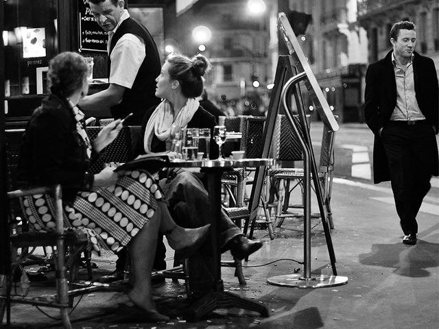 Two women ordering at a Parisian coffee shop.