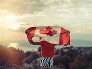 person holding a canadian flag over their head.