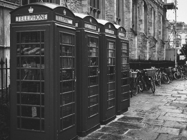 Black-and-white picture of four outdoor telephone booths.