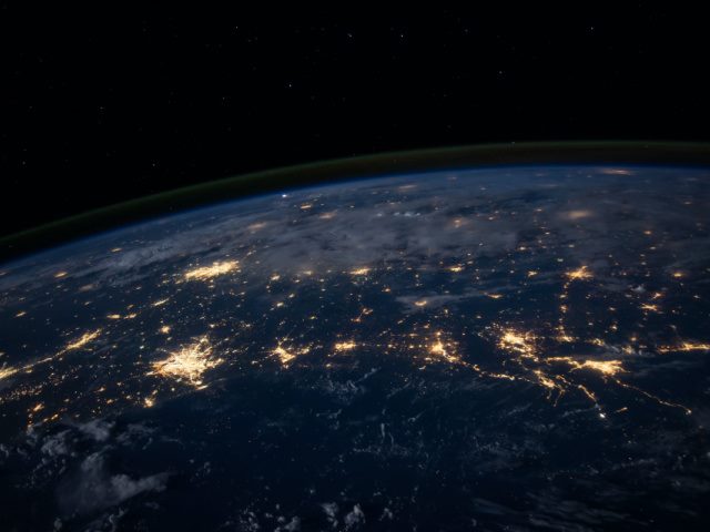 night time photo of Earth from space showing cities lit up brightly