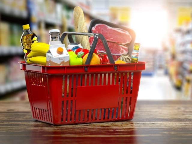 Red shopping basket with fresh food at a grocery supermarket. 