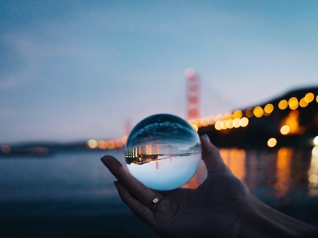 hand holding a crystal ball with Golden Gate Bridge in the background