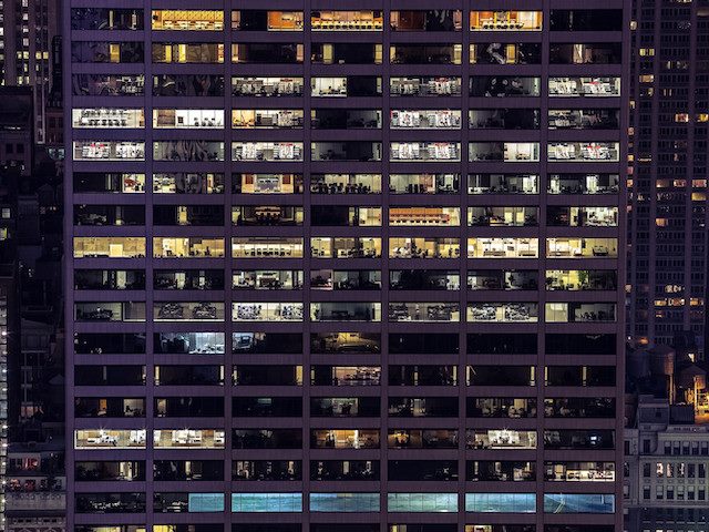 view from the outside of a well-lit office building at night