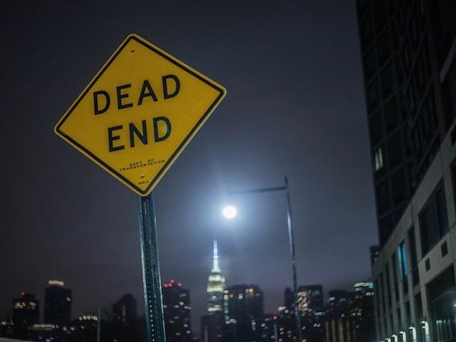 dead end sign with moon behind it