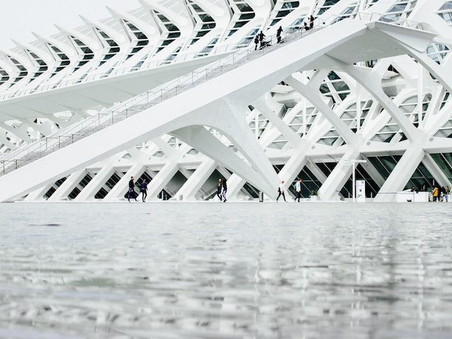 people walking under arches of a building