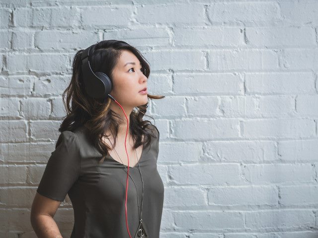 woman with headphones on looking up