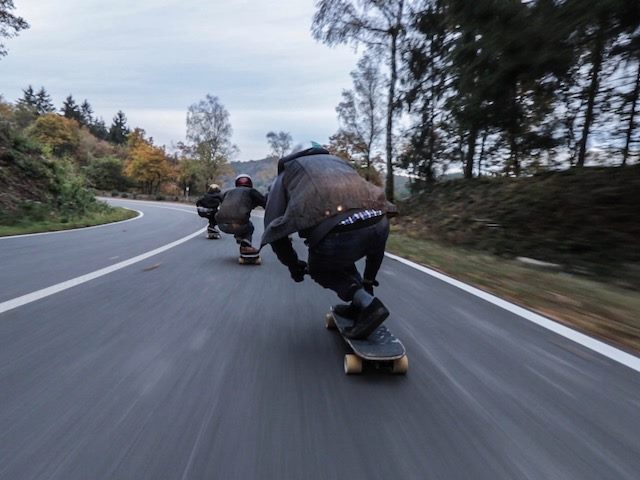 skateboarders rolling downhill