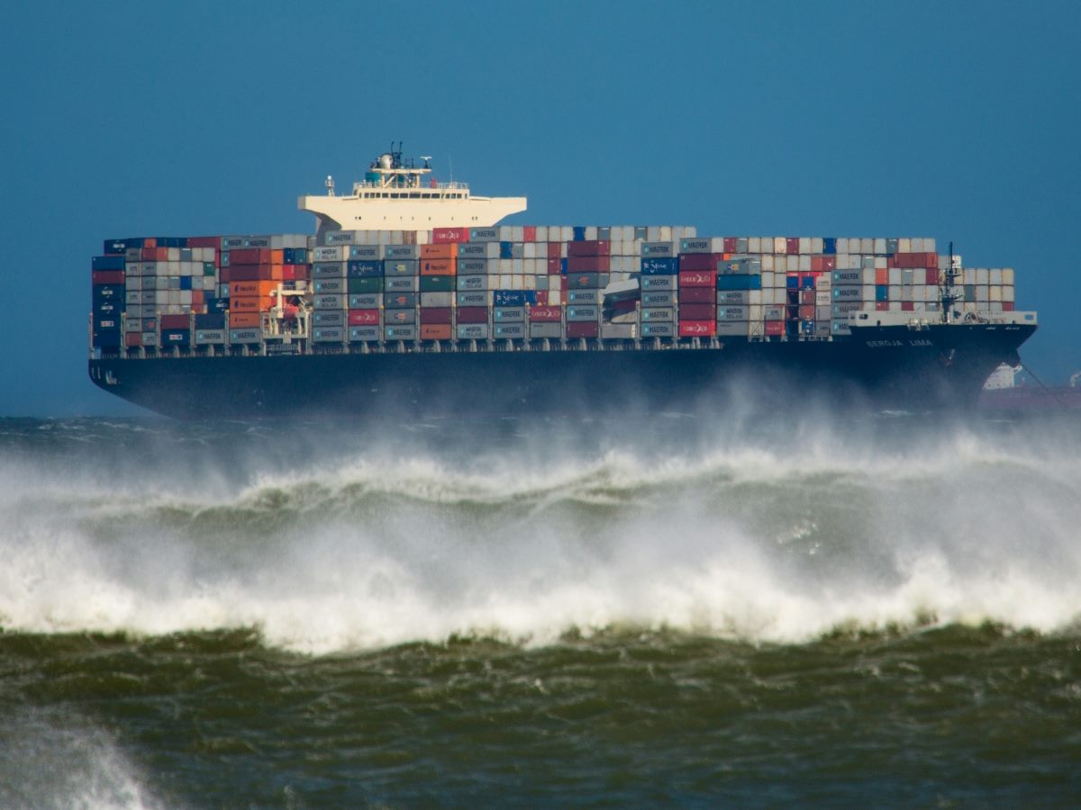 A shipping boat contending with rough waters.