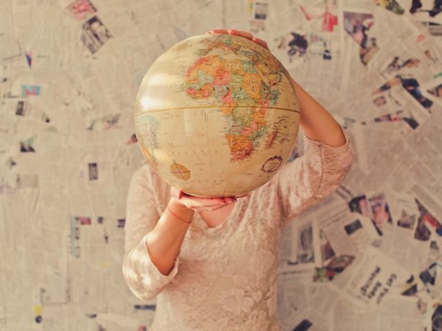 person with a globe in front of her face