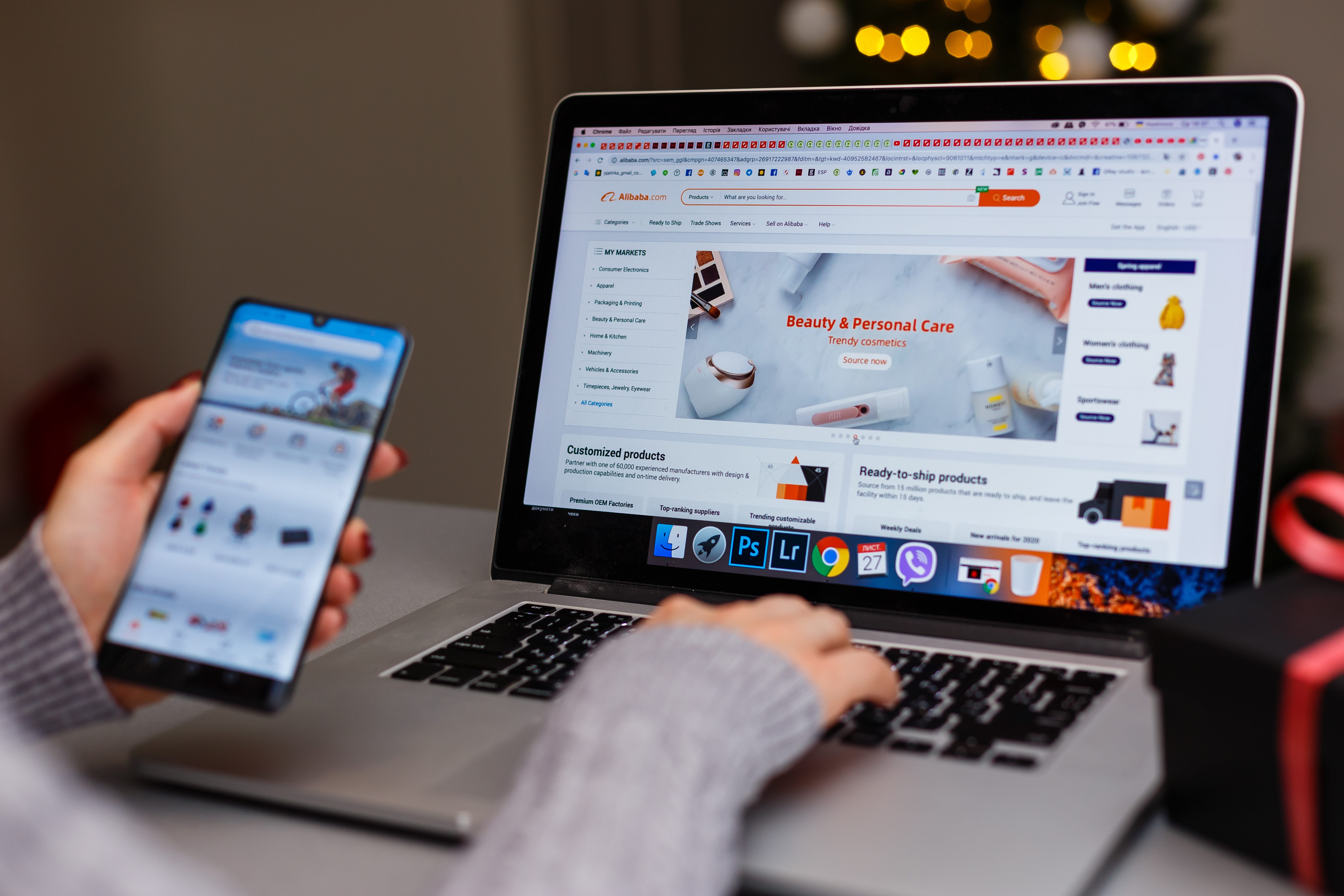 A person shopping online on both a computer and mobile phone.