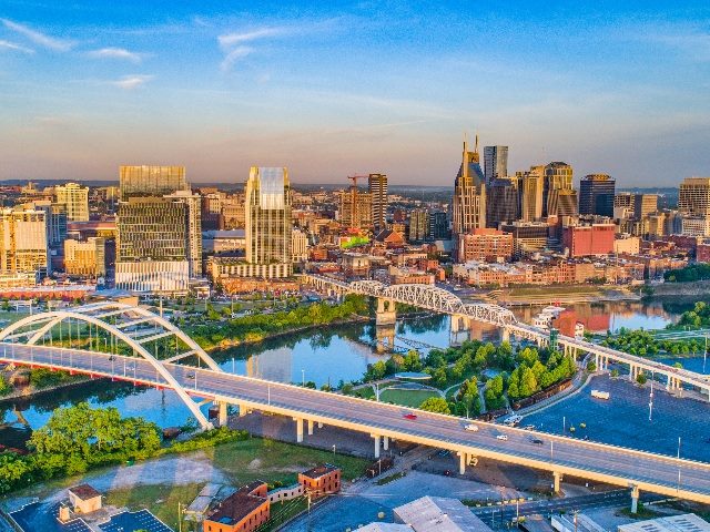 An aerial view of downtown Nashville, Tennessee, with blue skys and view of the Cumberland River and bridge, in piece reporting on Kentico Connection conference in Nashville.