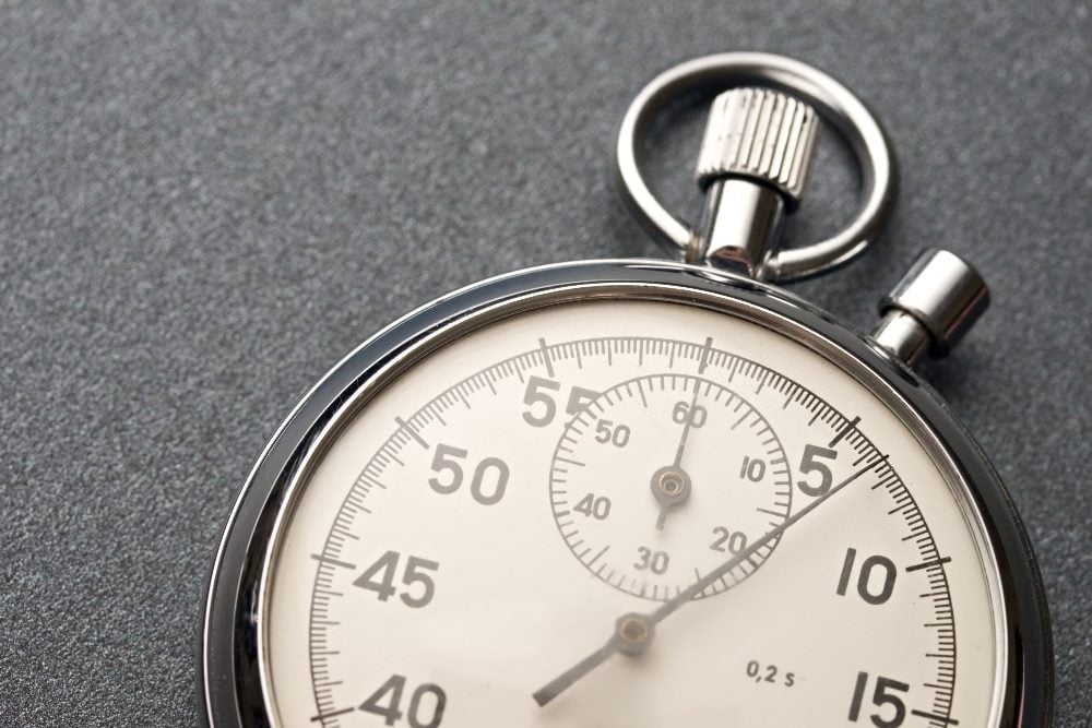 An analog stopwatch showing a close-up of its dial, with the time display prominently featured. This image represents the concept of 'average handle time' in customer service and call centers, highlighting the importance of managing and measuring call durations efficiently.