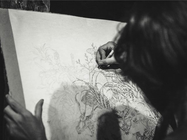 woman creating an intricate illustration
