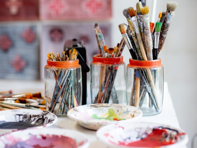 A table with paint and paint brushes 