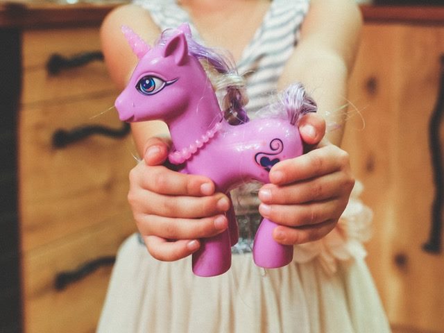 child holding a toy unicorn