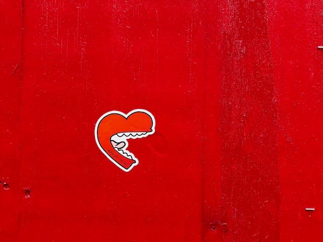 graffiti heart with a human mouth against a red background