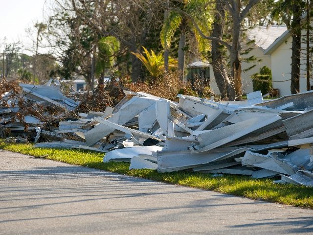 Heaps of debris on street side damaged by hurricane in Florida. 