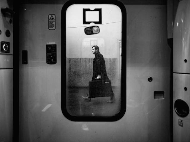person with portfolio seen through a train door