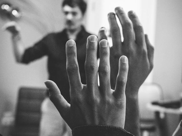 close up of raised hands, people waiting to ask a question in a lecture