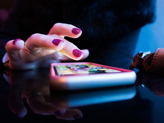 woman about to open a mobile app on her phone 
